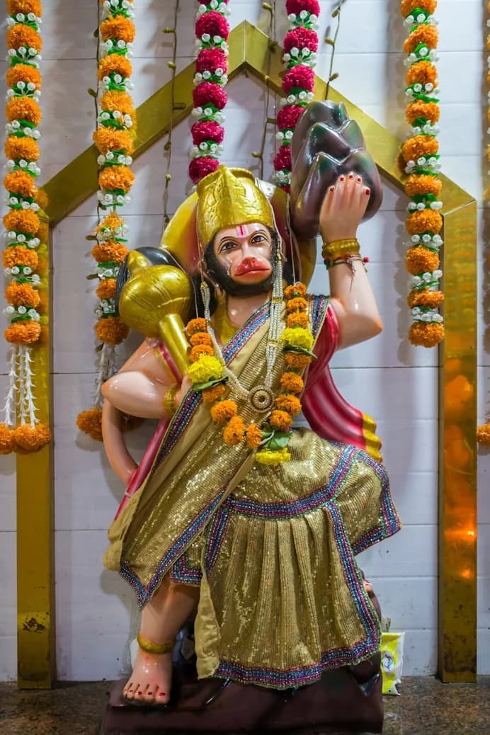 Garlanded statue of Hanuman, mace raised, in a Sri Lankan temple shrine