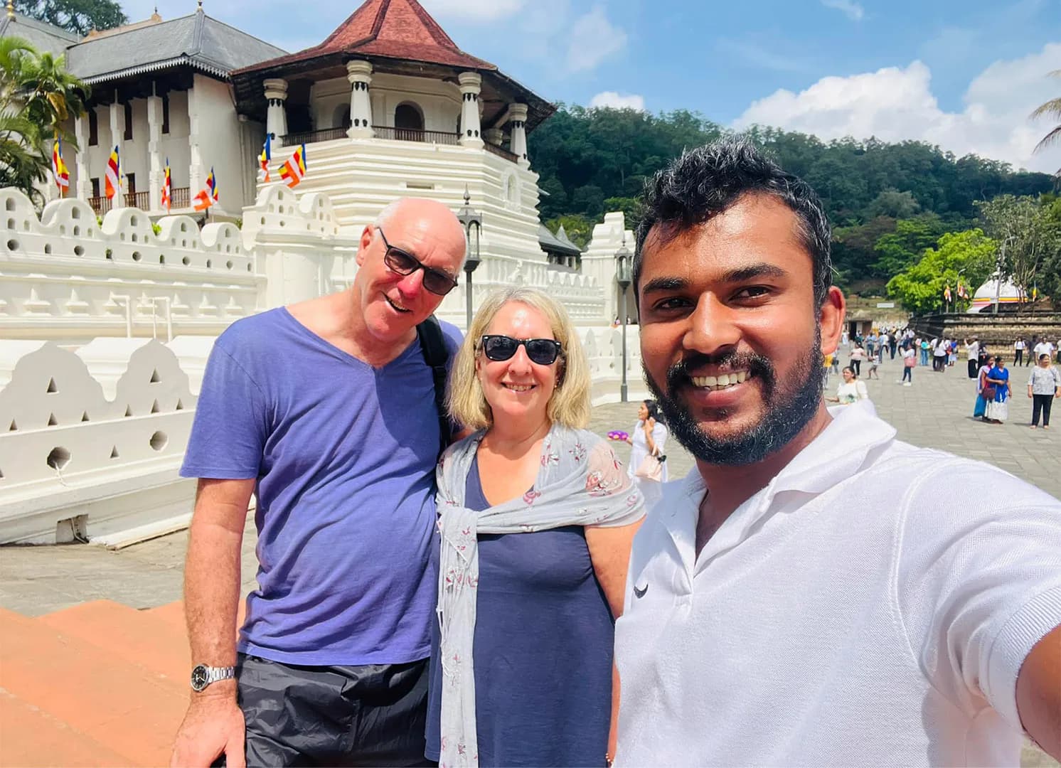 Two travellers with their Lanka Safe Tours guide outside the Temple of the Sacred Tooth Relic in Kandy